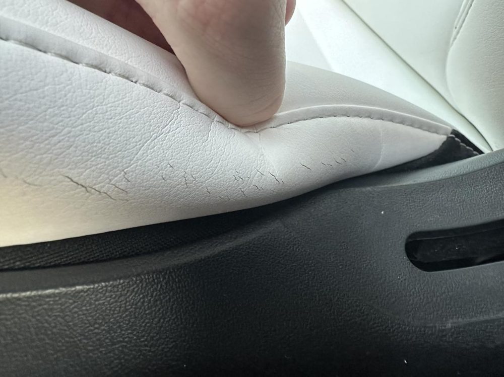 Cracked and sagging white Tesla seat leather and foam on the driver's bolster